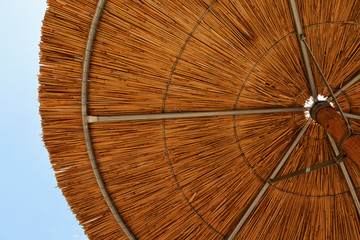 Rustic Wooden Beach Umbrella on a Clear Blue Sky