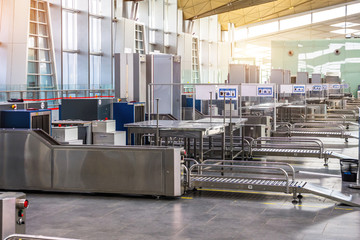 X-ray machine for screening passenger luggage with frame metal detector at the airport check-in counter.