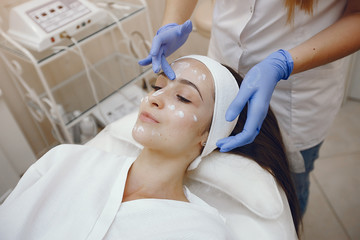 Cosmetologist treats client's skin. Woman with cosmetologist. Lady in a beauty studio.