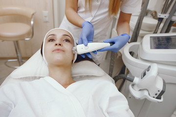 Fototapeta premium Cosmetologist use laser. Woman with cosmetologist. Lady in a beauty studio.