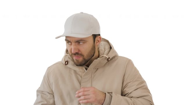 Man in winter outfit walking and coughing on white background.