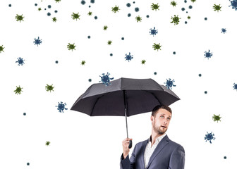 Young businessman under umbrella among coronavirus cells.
