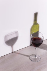 Shadow of wine glass in dark light.