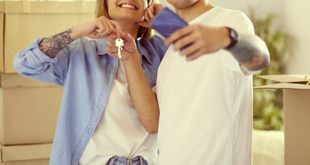 Young couple taking selfies with her smartphone in their new home