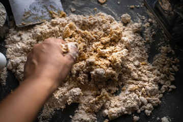 Process of making homemade wholewheat pasta in a kitchen with pasta sheet roller. Close up view. Dark photography