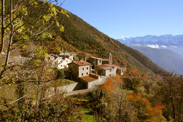 Village of the Pyrenees in the middle of the snow-capped mountains and with colorful vegetation