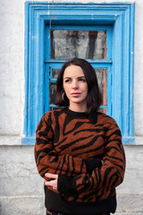 woman on the background of the window. brunette outside a residential building