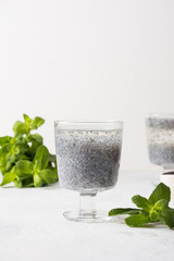 Detox beverage with basil seeds in glass on white background. Vertical format.