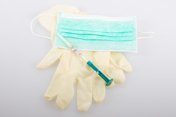 syringe mask gloves green blue on white background in covid-19 coronavirus pandemic concept
