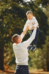 Family in a summer park. Father in a white sweater. Cute little son.