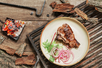 lunch grilled meat pork on vintage wood table in rustic style. Coals in the fire flame. BBC food.