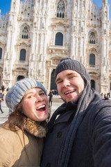 Travel, Italy and funny couple concept - Happy tourists taking a self portrait with pigeons in front of Duomo cathedral, Milan