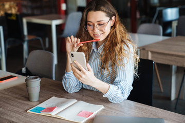 Image of joyful charming woman using cellphone and smiling