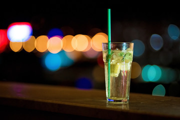 Mojito cocktail on a black background of night lights