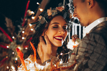 Stylish couple of brides, pretty woman in wedding dress and young man in fedora hat. Romantic...