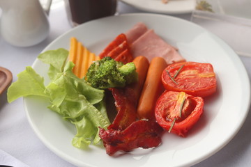 Bacon, Sausage, Tomato Breakfast on plate.