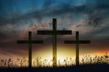 three wooden crosses at sunrise