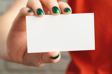Obraz premium Girl's hand holding blank white business card close up