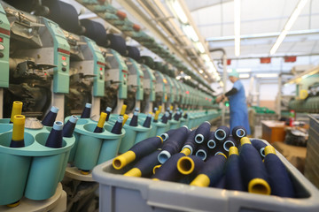 Close-up of the produced threads against the background of the production line. Factory for the production of threads and fabrics