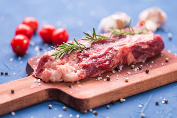 Fresh raw meat for steak on wooden cutting board.