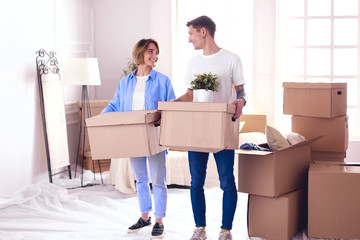 Couple holding boxes for moving the hands and looking inside box