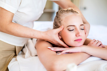 Obraz na płótnie Canvas Beautiful young attractive Caucasian woman having head massage by Thai Masseur in spa salon. Beauty treatment and body care lifestyle concept