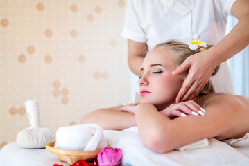 Fototapeta na wymiar Beautiful young attractive Caucasian woman having head massage by Thai Masseur in spa salon. Beauty treatment and body care lifestyle concept