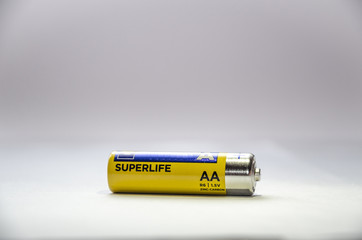 One yellow battery lies sideways on a white background.