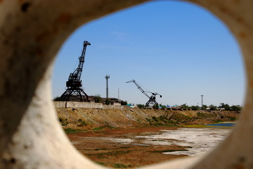 abandoned Aralks harbour with cranes and dry sea