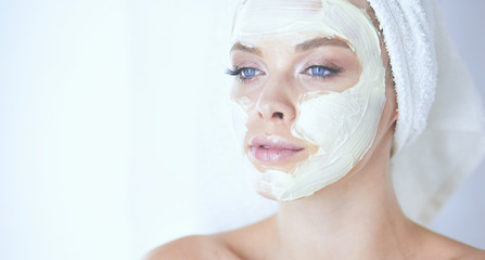 A picture of a young woman applying face powder in the bathroom