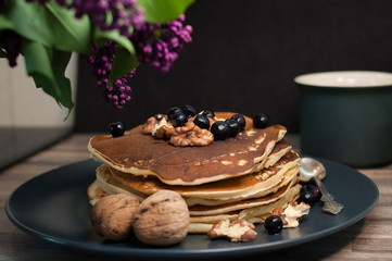 .morning breakfast pancakes .fritters with honey nuts and currants lilac copy space
