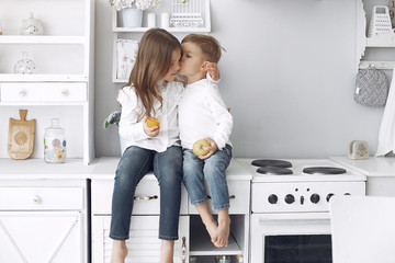 Cute little child at home. Family in a kitchen. Little girl in a white blouse.