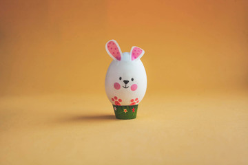 white egg in the form of an Easter Bunny on a brown background