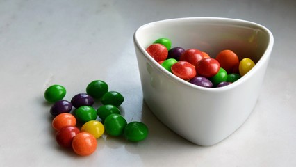 Multicolored fruit candies in the small bowl. Panoramic view