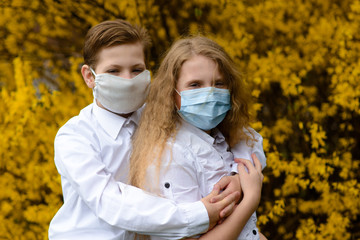 Children in a city park in a medical mask. Walking on the street during the quarantine period of the coronavirus pandemic in the world. Precautions and teaching children