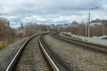 Fototapeta premium The railway goes into the distance. Rails, sleepers, poles with wires. Spring day
