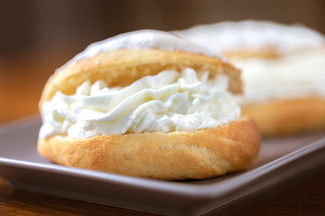 Close up of whipped cream into a sweet brioche.