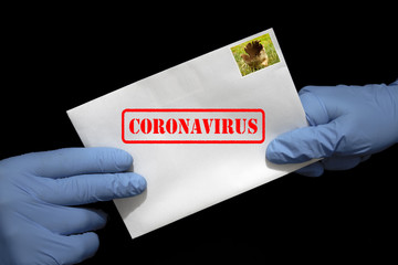 Ludzkie ręce w rękawicach ochronnych z listem, który może zawierać wirusa COVID-19. Przesyłki pocztowe mogą rozprzestrzeniać koronawirusa.

