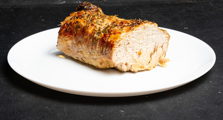 A large piece of baked meat on a white plate
