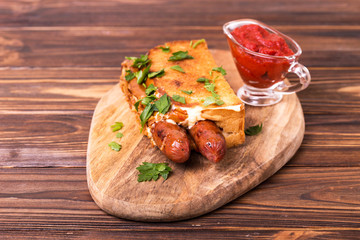 Double hot dogs with french brioche buns and caramelized onions with mayo sauce and ketchup.
