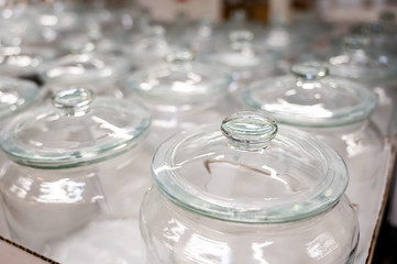 A group of empty cans with a lid. Rows of glass containers in a store. Close-up.