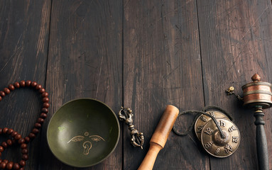 Copper singing bowl, prayer beads, prayer drum and other Tibetan religious objects for meditation...