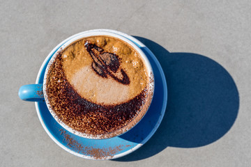 Latte art Coffee decoreded with Saturn image in blue cup