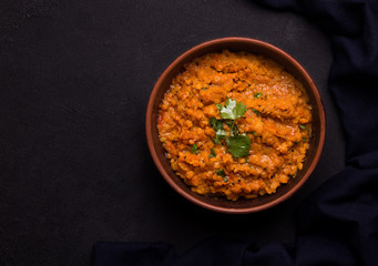 Dhal Indian traditional lentil soup in a clay bowl on a black background copy space. Rustic