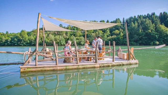 A family of visitors having a traditional Slovenian experience on a raft ride on Drava river