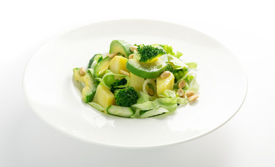 Green Salad with Avocado, Cucumber and Nuts on White Plate