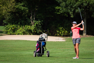 Junge Golferin im Durchschwung 