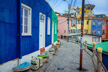 Obraz premium Panoramiczny widok na górskie wzgórza z kolorowymi i jasnymi budynkami z malowaniem, Valparaiso, Chile