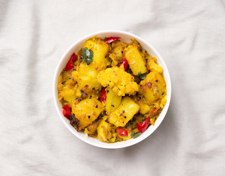 Gobi Aloo traditional Indian dish of cauliflower and potatoes on a gray linen fabric