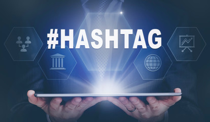 Businessman holding a computer tablet display projecting a Hashtag concept.